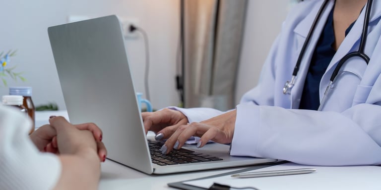 A doctor uses a laptop to analyze patient data